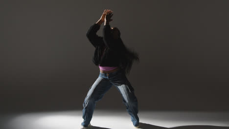 Retrato-De-Estudio-De-Longitud-Completa-De-Una-Mujer-Joven-Bailando-Con-Iluminación-Baja-Sobre-Fondo-Gris-5